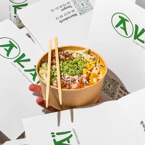 Poke bowl dans son bol kraft, posé sur les emballages signés Akai
